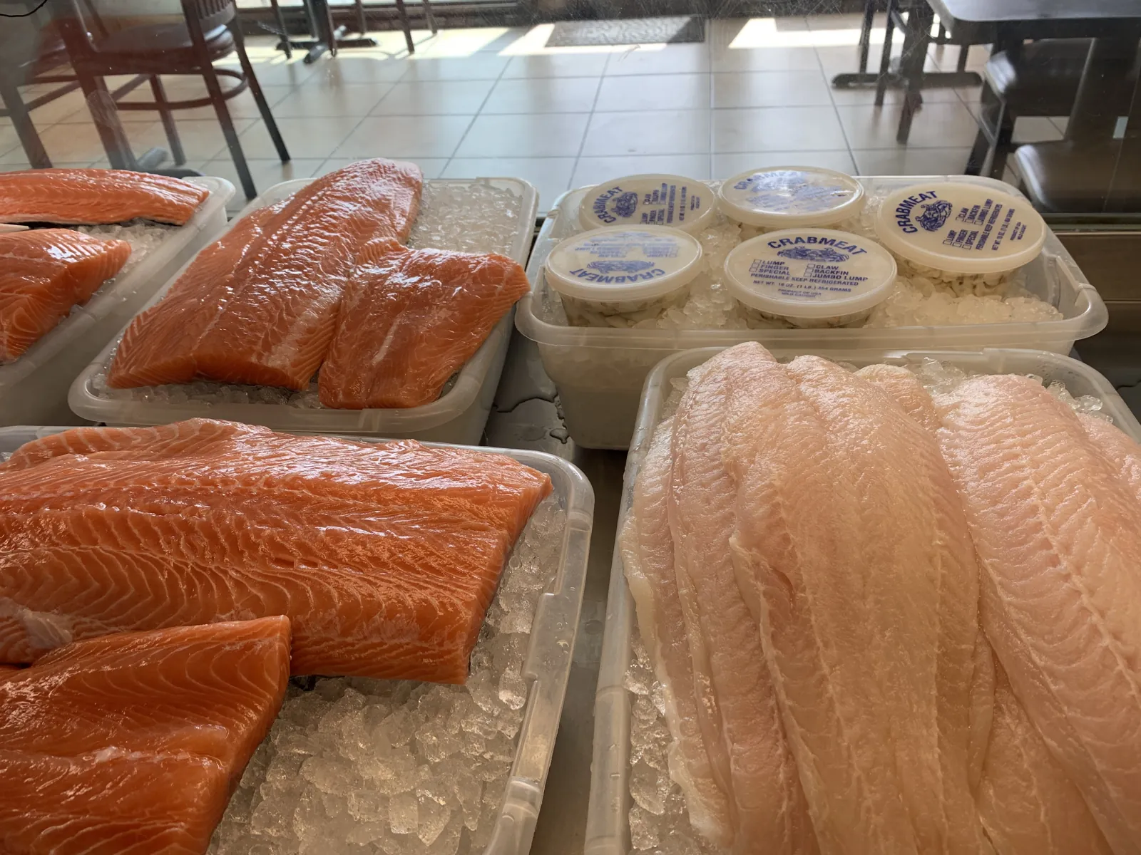 Fresh salmon and boneless white fish fillets at the market counter
