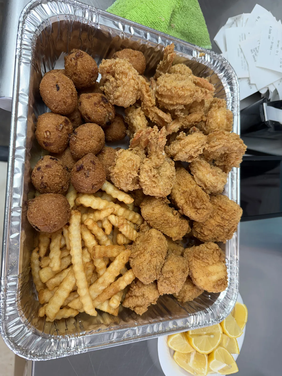Fried catfish, shrimp and hush puppies in a takeout tray