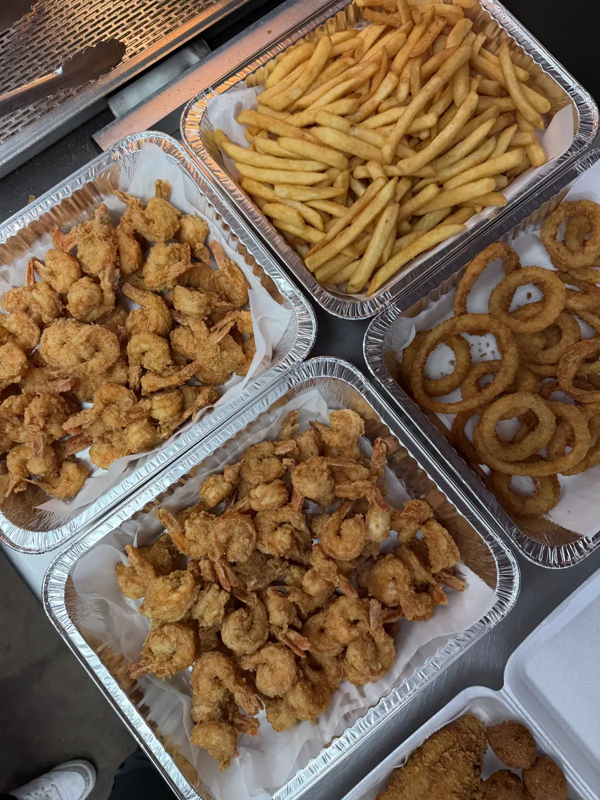 Fried shrimp trays with fries and onion rings at Fountain View Fish Market in Houston